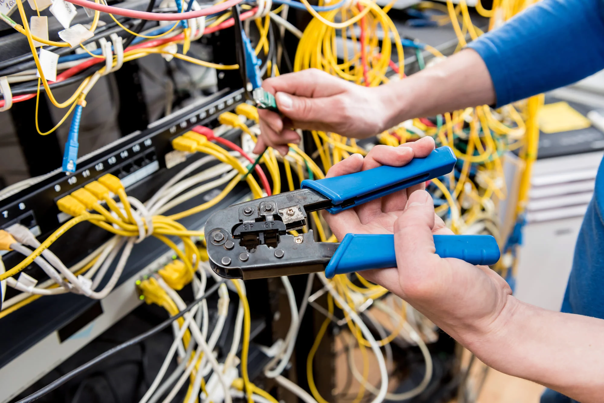 network-engineer-working-server-room-connecting-network-cables-switches